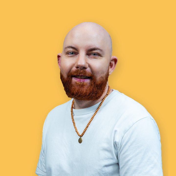A headshot of Samuel Johns on a yellow background.