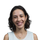 un cliché de l'auteure Yolaine Amaro prise à l'extérieur sur un fond flouté de bâtiments et d'arbres