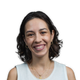 un cliché de l'auteure Yolaine Amaro prise à l'extérieur sur un fond flouté de bâtiments et d'arbres